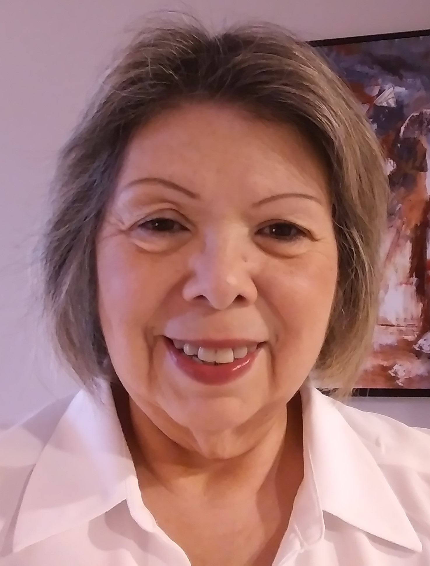 Photo of Margaret Castro is white blouse, short brown hair, smiling